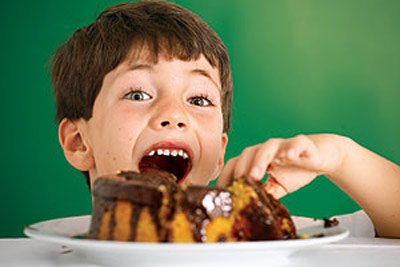 Criança comendo bolo de cenoura